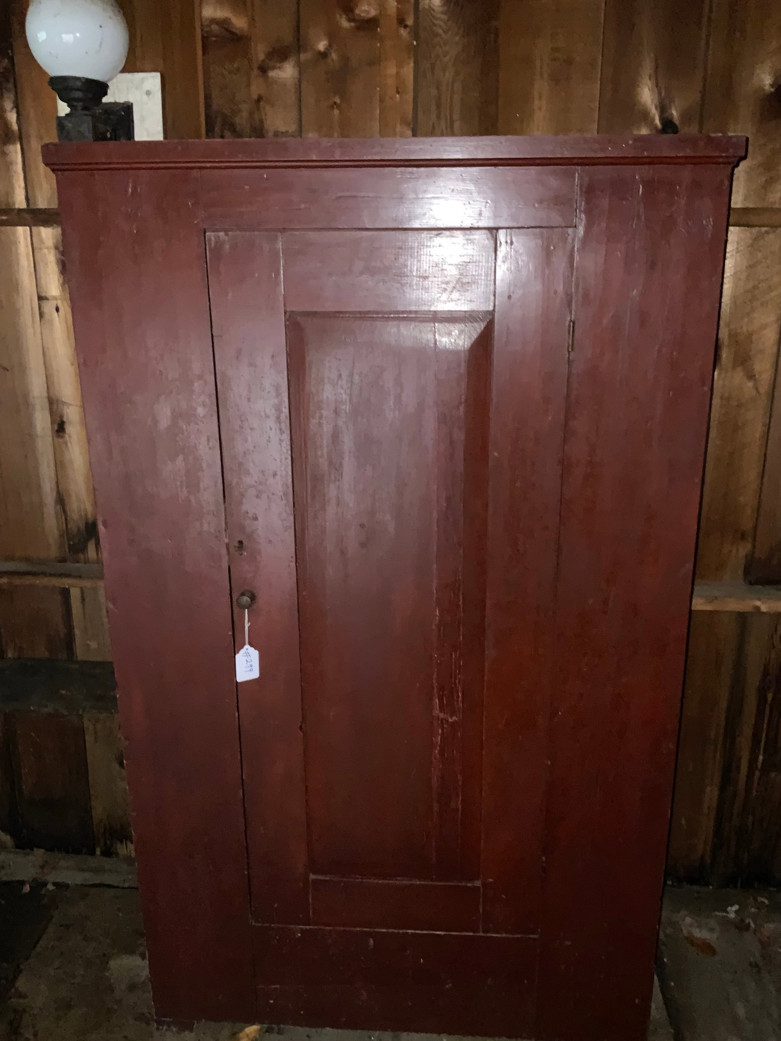 Wardrobe: Wardrobe, late 19th century, single raised panel door, varnished red surface, 43 1/4" wide, 17" deep, 74" tall, has two shelves added, wardrobe pole missing, hole cut into the back. Overall good