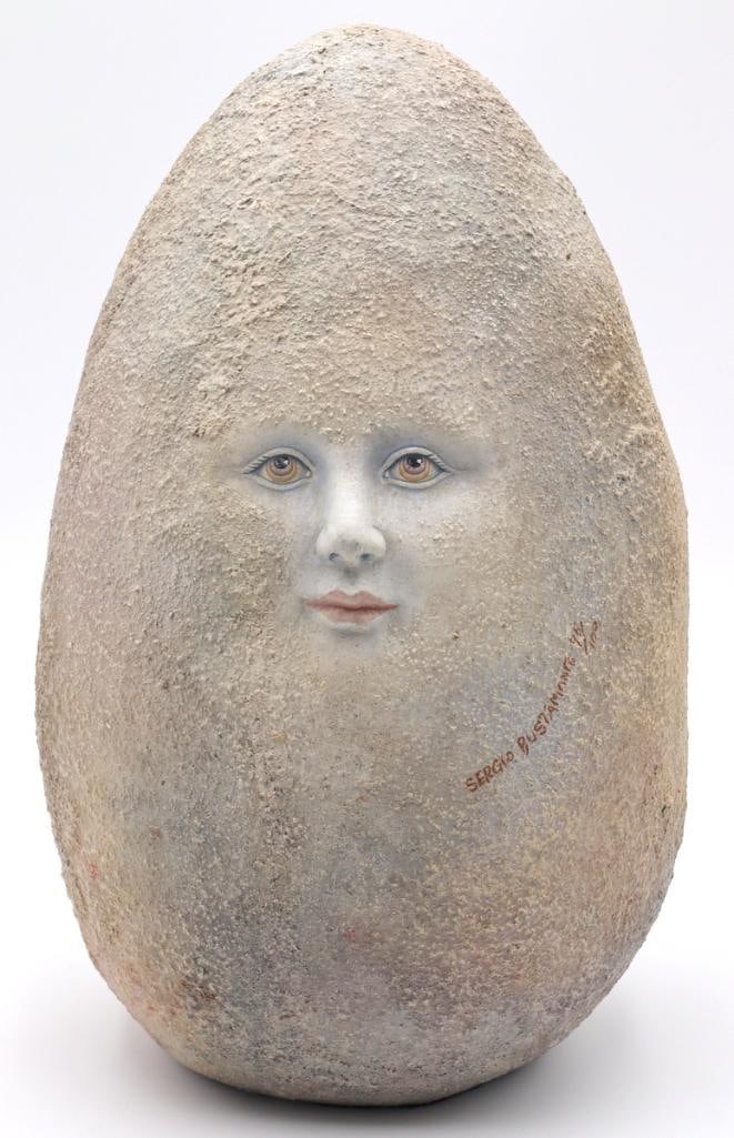 Sergio Bustamante (Mexican, b. 1949) “Moon Egg” Ceramic Sculpture: Sergio Bustamante (Mexican, b. 1949) “Moon Egg” Painted ceramic sculpture Surrealist egg-form sculpture featuring a textured surface with a delicately painted human face emerging from the 