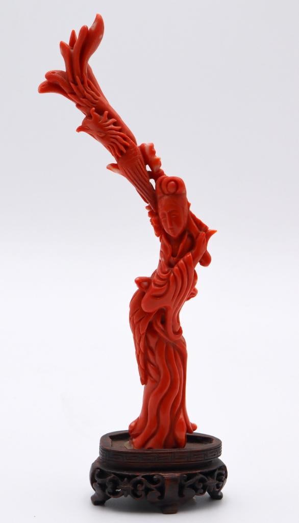 Chinese Carved Coral Sculpture of Guanyin with Phoenix: Chinese Guanyin with Phoenix Carved coral sculpture on wooden stand Carved coral figural group depicting Guanyin in flowing robes beneath a large phoenix with outstretched plumage. Raised on a carved 