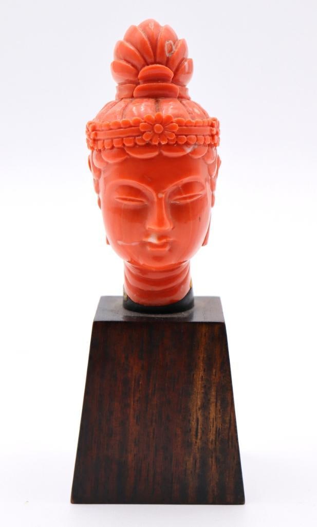 Chinese Carved Coral Buddha Bust: Chinese Carved Coral Buddha Bust Coral on wooden pedestal Finely carved coral bust depicting the Buddha with a serene expression, elongated earlobes, and an elaborately detailed coiffure and headdress