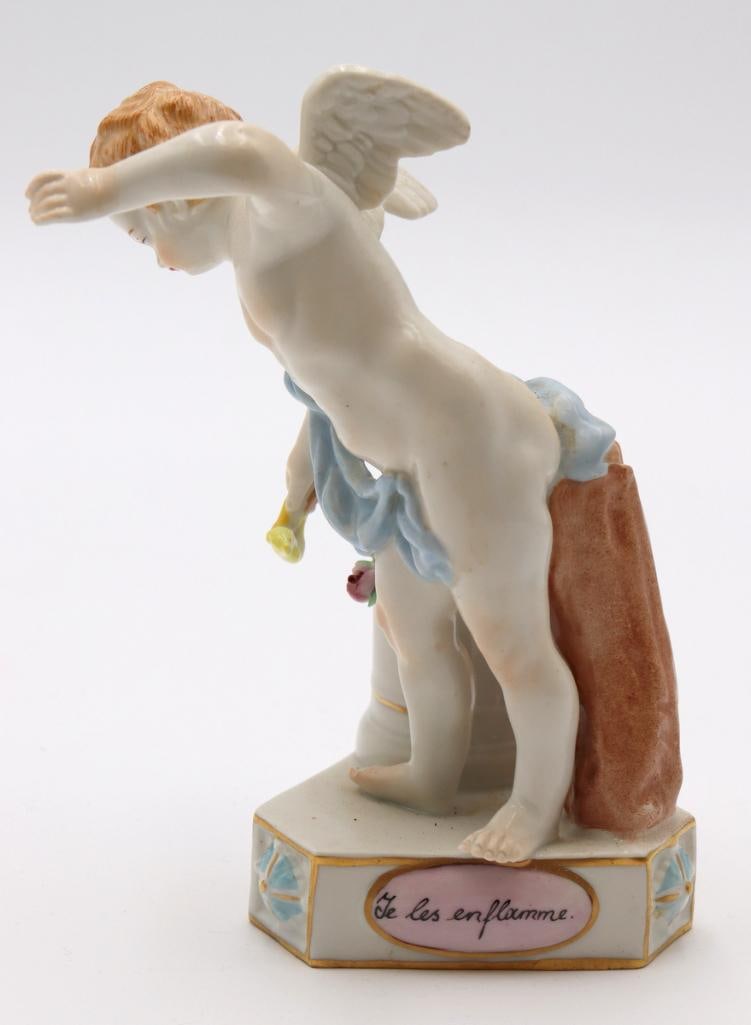 Antique Dresden Cherub Porcelain Sculpture: Dresden (German) “Je les enflamme” Hand-painted porcelain cherub sculpture Antique hand-painted porcelain figure depicting a winged cherub in a dynamic pose, modeled with pastel-colored dr