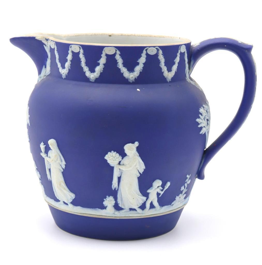 Wedgwood Dark Blue Jasperware Pitcher: Wedgwood (British, est. 1759) Dark Blue Jasperware Pitcher Antique dark blue jasperware pitcher decorated in white relief with classical figures and floral garlands. Impressed “WEDGWOOD” a