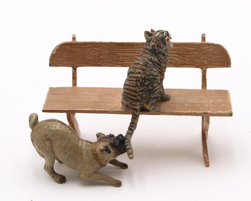 Vienna Cold-Painted Bronze Cat and Dog Sculpture: Vienna Cold-Painted Bronze Cat and Dog Sculpture Vienna cold-painted bronze figural sculpture depicting a cat seated on a bench with a dog playfully biting its tail. Measurements approx. - 2 in. high 