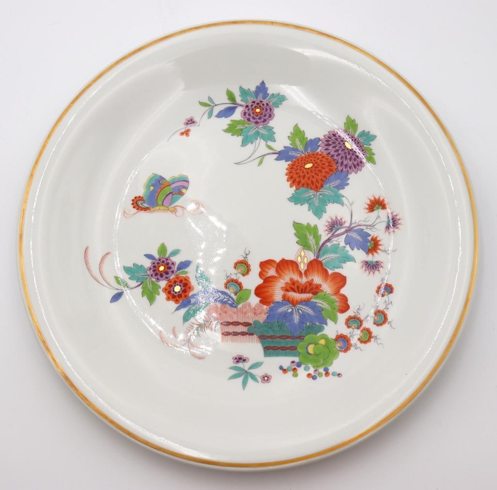 Meissen Kakiemon-Style Porcelain Charger: Meissen Vintage Kakiemon-style porcelain charger Porcelain charger featuring a hand-painted polychrome floral and butterfly motif in the Kakiemon style, finished with a gilt rim. Underside bearing blu