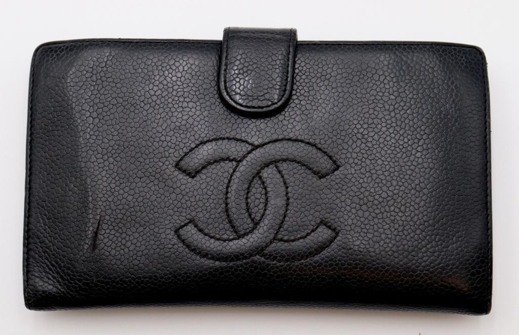 Chanel Black Caviar Leather Long Wallet: Chanel (French, est. 1910) Caviar Leather Long Wallet Circa 2004 Vintage Chanel long wallet crafted in black caviar leather, featuring an embossed interlocking CC logo to the front and a tab closure. 