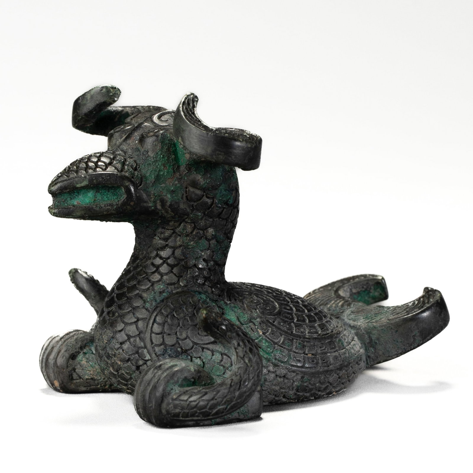 A BRONZE PHOENIX-FORM MAT WEIGHT: Height 2 3/8 in. (6 cm), Width 3 9/16 in. (9 cm)