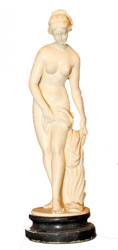Female Nude Statuette by Santini: This is a Classical Style Statuette of a female nude reaching for a shell. Made by Santini and signed. DIMENSIONS: Diameter: 4 3/8 inches Height: 14.5 inches