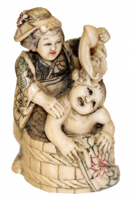 Japanese Ivory Netsuke of Woman Bathing a Child: This is a Signed Japanese Antique Ivory Netsuke Carving of a woman washing a child. She has very nice detailing and color on her kimono. DIMENSIONS: Length: 1.25 inches Width: 1.25 inches Height: 2 in