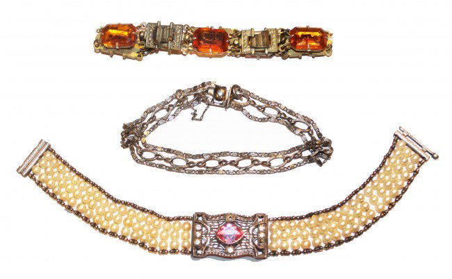 Three vintage bracelets: Three vintage bracelets: One has pearls and pink and clear stones. One is gold-colored with amber stones. One is signed "Lang" appears to be sterling but we could not find it marked.