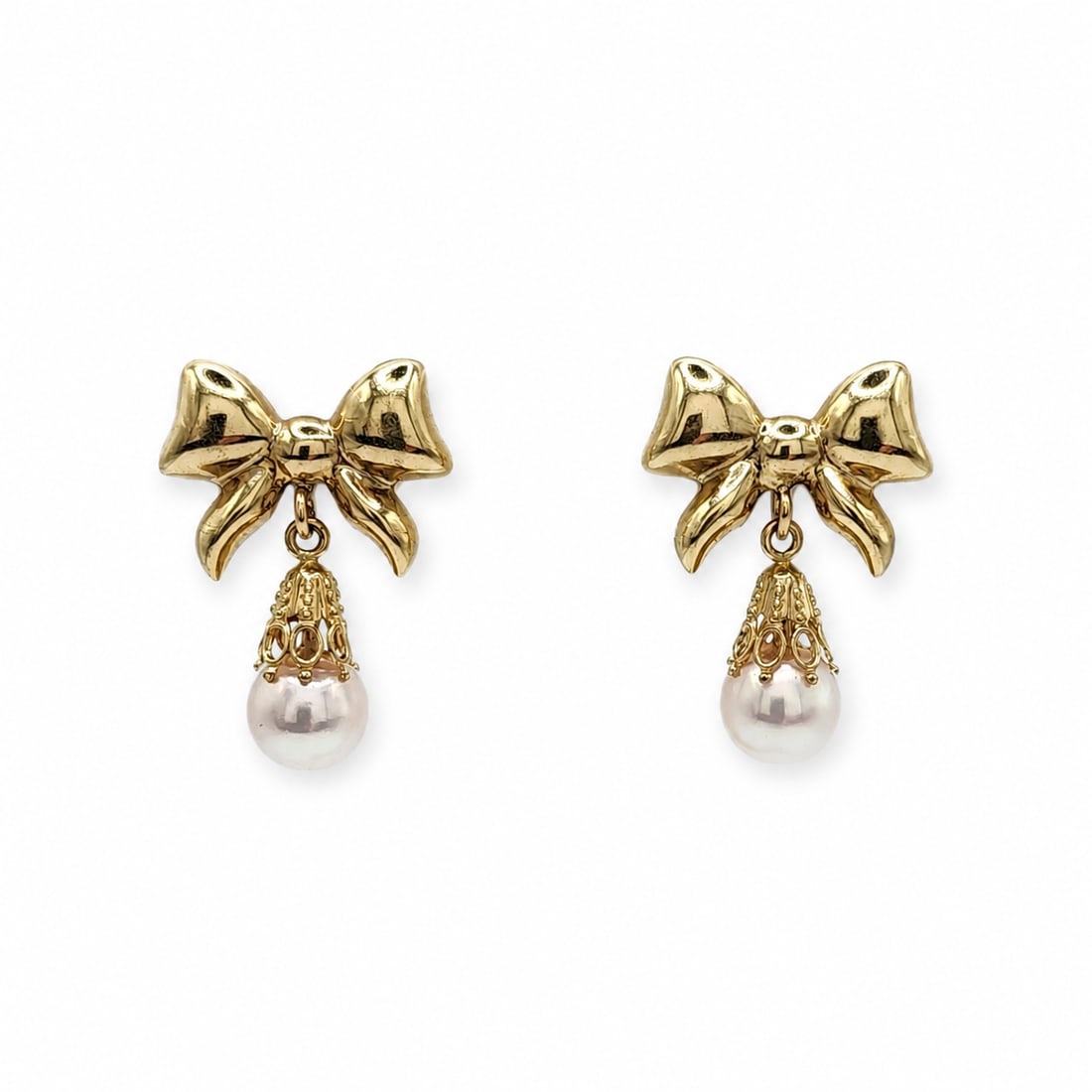 Yellow gold pearl earrings: A 14kt yellow gold earrings. White pearl 7mm. .95x .65 inches. 3.55 grams.