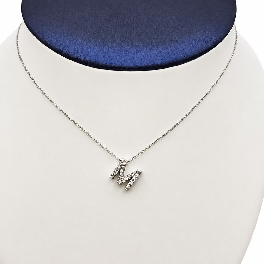 White gold Diamond letter M pendant with chain: A 14kt white gold "M" pendant with 16 inches 14kt white gold chain. Diamonds .20 ct. Pendant .38x.38 inches. 3.40 grams