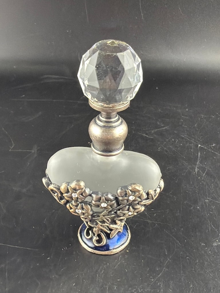 Vintage Style Jeweled Pewter Floral Overlay Heart Frosted Glass Perfume Bottle: A romantic, vintage-style miniature decorative perfume bottle designed with an ornate mixed-media aesthetic. The central flask features a heart-shaped, translucent satin frosted glass vessel. The lowe