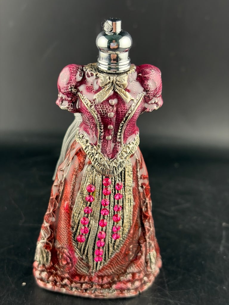 Ornate Enameled & Jeweled Victorian Dress Gown Figural Perfume Bottle with Tassel: An ornate, figural collector's perfume bottle crafted in the shape of a Victorian-era gown or fashion dress form. The structural metal or resin body features highly detailed textures mimicking lace, b