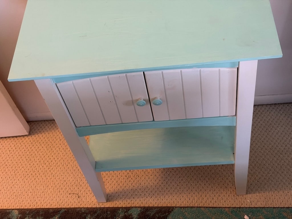 Painted Coastal Cottage-Style Wood Nightstand with Cabinet and Shelf: Painted pale aqua and white nightstand or side table with a rectangular top, shallow drawer, paired beadboard-style cabinet doors with round aqua knobs, and an open lower shelf. The top measures appro