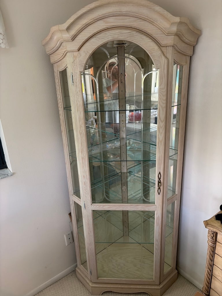 Pickled Oak Glass Curio Display Cabinet with Mirrored Back: Tall curio cabinet in a pale pickled finish, with an arched molded crest, glass-paneled door and sides, adjustable glass shelves, and a mirrored interior back. Decorative curved and beveled glass elem