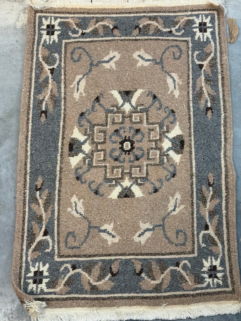 Elegant Vintage Area Rug with Floral Design: "Elegant Vintage Area Rug with Floral DesignThis beige and blue area rug features a detailed floral pattern with a central geometric motif and decorative fringes on the edges."