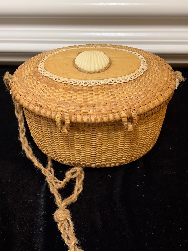 Vintage Woven Basket with Shell Lid: "Woven Lidded Nantucket-Style Basket with Shell DecorationOval woven basket featuring a fitted hinged lid, decorative shell medallion, ivory-tone toggle closure, ribbon accents, and rope-style