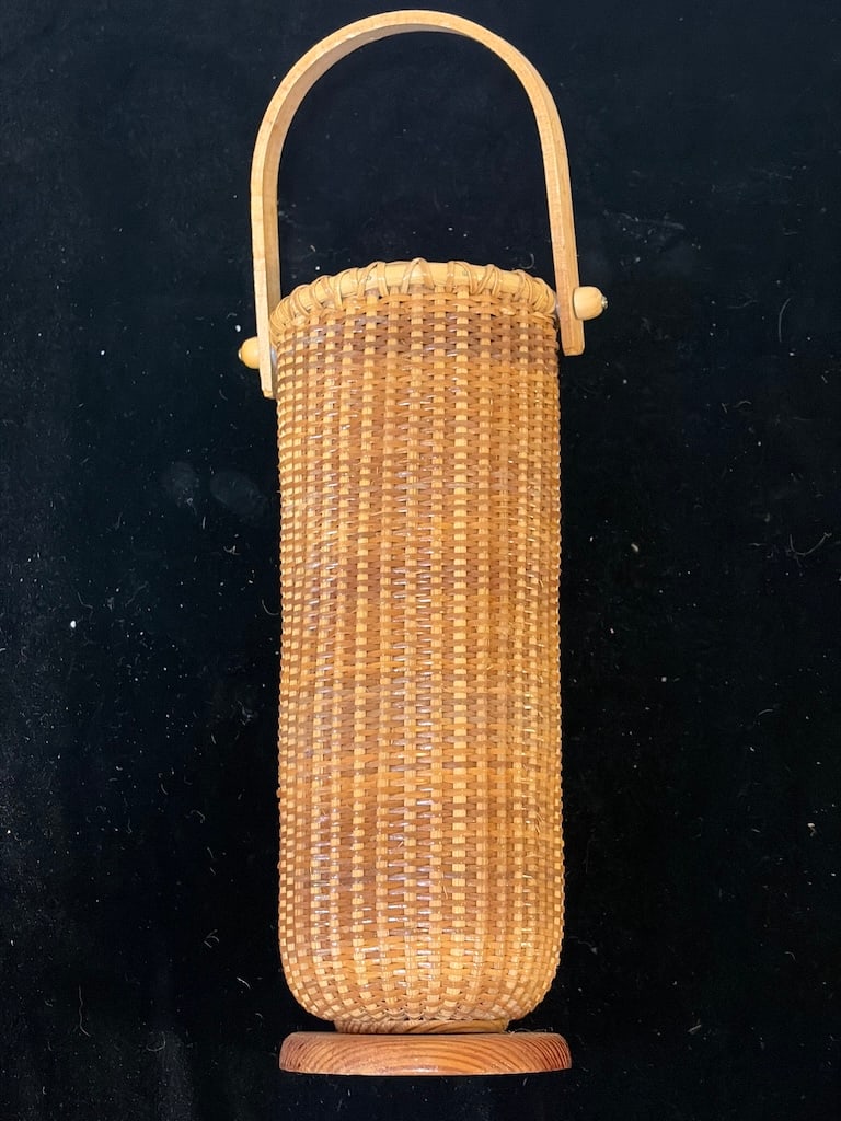 Vintage Nantucket-Style Woven Tall Cylindrical Basket with Swing Handle: "Vintage Nantucket-Style Woven Tall Cylindrical Basket with Swing HandleFinely woven Nantucket-style cylindrical basket featuring a natural wood base, tightly woven cane body, reinforced rim, and tall