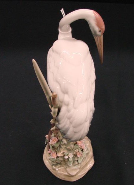 Lladro Figurine "Preening Crane" #1612, Depicts Cr: Lladro Figurine "Preening Crane" #1612, Depicts Crane Preening its Feathers. Issued 1989, Retired 1998. The Crane Figures are Very Difficult to Find. 7.5"H x 4.5"W. Auction Estimate:$400-800.