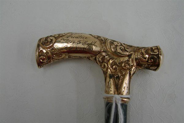 19th Century Ebony Gold Repousse Walking Stick: 19th Century Ladies Ebony Walking Stick Embossed Gold Handle bearing illegible inscription. 34.5" in length. Auction Estimate $100-200.
