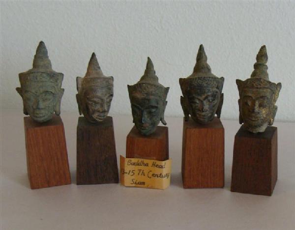 5 Antique Bronze Siam Buddha Heads: Set of 5 Antique Bronze Siamese Miniature Buddha Heads mounted on wooden bases. Heads are noted by previous owner to be Circa 13th to 15th Century Siam, but Orientalia is not our specialty. Ranging in