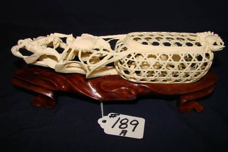 Chinese Carved Ivory Crab Trap: Chinese Carved Ivory Crab Trap with Intricately Open Work Carved Trap Containing 2 Crabs Surrounded by 3 Additional Crabs on Fitted Carved Wooden Stand, 8" Length. Auction Estimate $700-900. ALL IVORY