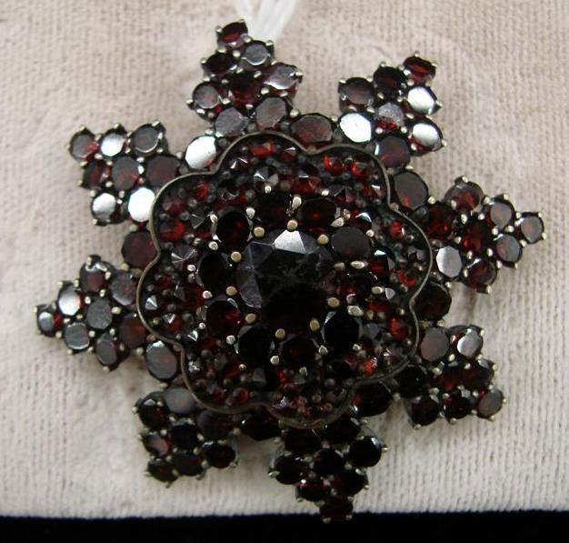 Victorian Antique Bohemian Garnet Starburst Brooch: Victorian Antique Bohemian Garnet Starburst Brooch. Set in Silver Vermeil with an Early C-Clasp Closure. Over 75 Garnets surround a large center. Auction Estimate: $200-400.