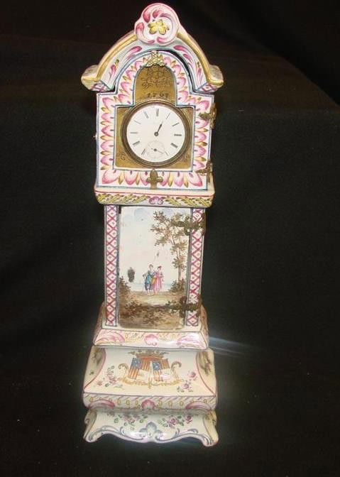 18th Century Porcelain Watch Holder in the Shape o: 18th Century Porcelain Watch Holder in the Shape of a Grandfather Clock, Dated 1767. Scenes Depict Girl & Boy Going to Lake, Florals, Flags & Ornate Decoration. 11 3/4" h x 4"w. Note: Stress Lines on