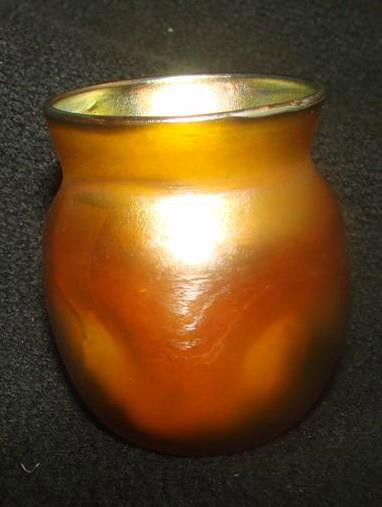 Signed Tiffany Gold Aurene Art Glass Tooth Pick Ho: Signed Tiffany Gold Aurene Art Glass Tooth Pick Holder with Pinched Sides. 1.75" h; 1.5" Diameter. Signed on Bottom, L.C.T.(Louis Comfort Tiffany) Auction Estimate: $150-250.