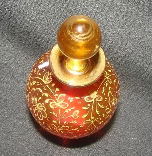 Antique Ruby Art Glass Enameled Cologne Bottle. De: Antique Ruby Art Glass Enameled Cologne Bottle. Decorated with All-Over Enamel Gold Florals and Leaves on a Ruby Red Background. Attributed to Moser or another famous Bohemian Art Glass Maker. Auction