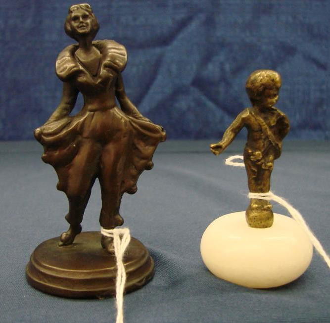 Two Miniature Bronze Statues: Two Miniature Bronze Statues – A Little Boy with Sack Over his Shoulder on a Round Marble Base, 2.75" ht; and an Art Deco Lady with Flared Pants and Collar, 3.5" ht. Auction Estimate: $100-200.