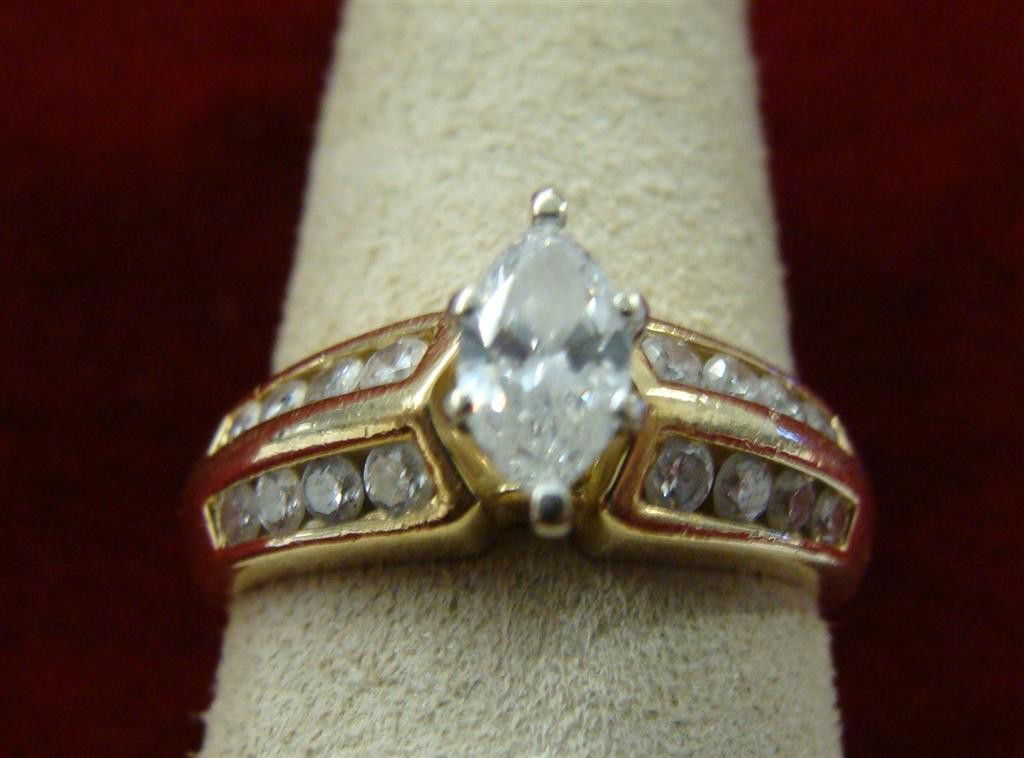 14K Yellow Gold Diamond Ring 1/2 ct Marquis Sz 6.5: 14K Yellow Gold Diamond Ring with 1/2 ct Marquis Diamond in Center, Accented by 2 Rows of Channel Set Diamonds on Each Side. Size 6.5; 5.2 Grams. Auction Estimate $600-800.