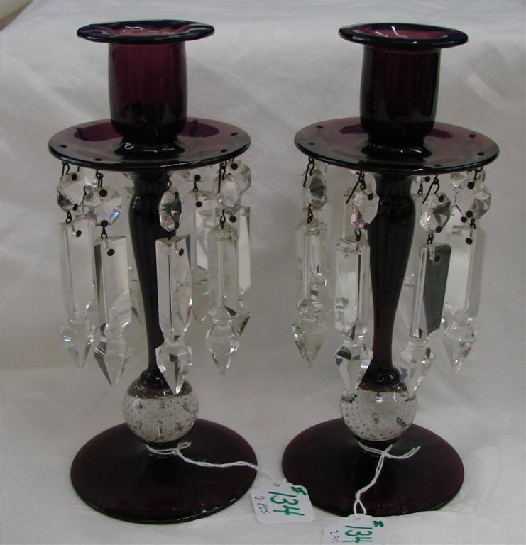 Pair Amethyst Glass Pairpoint 9" Lusters w Prisms: Pair of Amethyst Glass Pairpoint 9" Lusters / Candle-holders with Hanging Crystal Prisms. Auction Estimate $200-300.