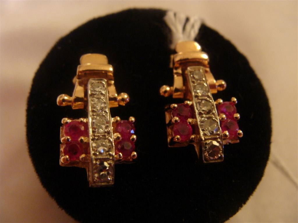 14K Yellow Gold Diamond & Ruby Hinged Earring: 14K Yellow Gold Diamond & Ruby Hinged Earrings; These pierced earrings have a striking art deco era geometric pattern – a row of 5 round diamonds set in white gold down the center with 2 round rubie