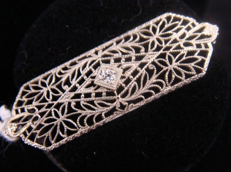 Art Deco 10K White Gold & Diamond Filigree Brooch: Antique Art Deco 10K Solid White Gold Diamond Filigree Brooch; 1.75" L. 2.4 Grams. Auction Estimate $100-200.