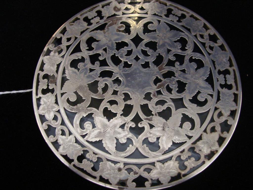 Sterling Silver Overlay: Webster Trivet & a Lidded: Two Sterling Silver Overlay Items: Includes 2 items which are both silver overlaid on clear glass: a 6" Diameter Trivet and a 4.5" Ht x 2.5" Diameter Jar. Trivet is signed Webster. Approximate Total W