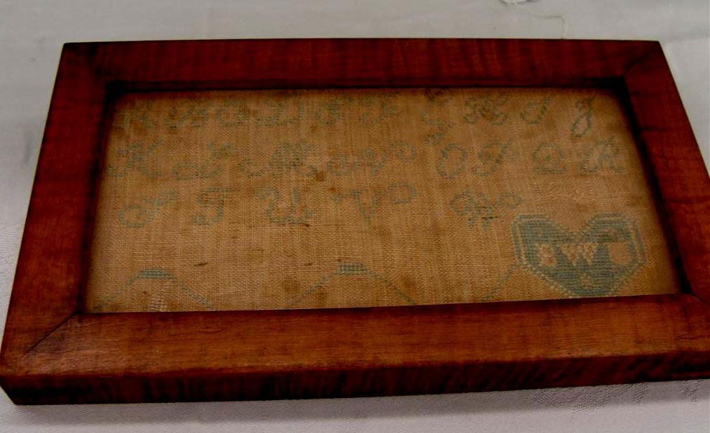 Antique Handmade Americana Sampler Dated 1811 w/I: Dated 1811 Handmade Americana Sampler; Framed Under Glass; Artist Initialed in Heart Shape on Lower Right. 4" x 8". Auction Estimate $100- 200.