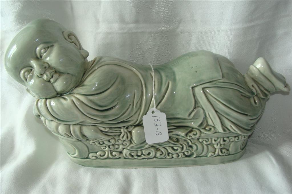 Chinese Celadon Figural Pillow: Chinese Celadon Figural Pillow in the Form of an Infant on a Bed. 15" Length, 7 1/8" Ht & 4" Wd. Auction Estimate $200-400.