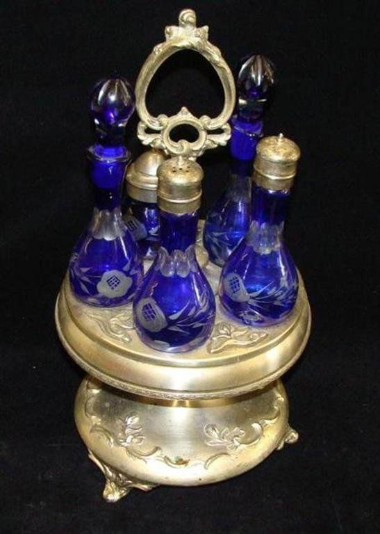 Antique Silver Crystal Castor Set with Blue Cut to Clea: Antique Silver Crystal Castor Set with Blue Cut to Clear Bottles. Revolving Castor Has Floral & Scroll Decor. Auction Estimate: $200-300.