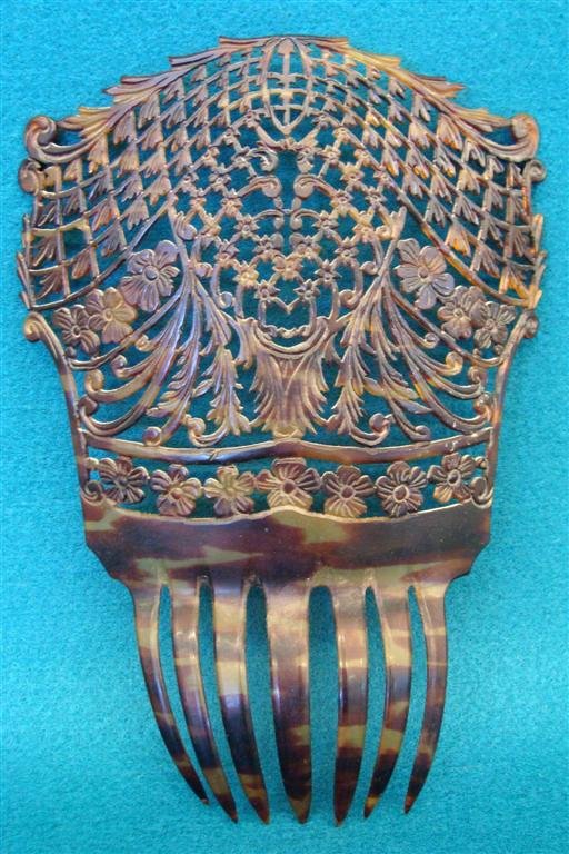 Elaborate Antique Hair Comb, Pierced Floral Design on T: Elaborate Antique Hair Comb, Pierced Floral Design on Top with Band Of Flowers at Hair Line, Tortoise Shell Color. Auction Estimate: $100-200.