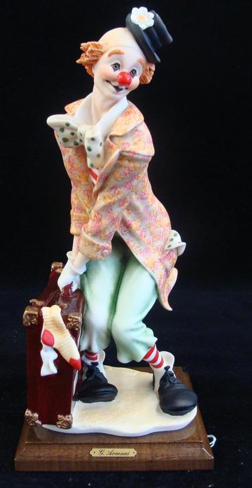 Giuseppe Armani Figurine: The Traveling Clown; #663E; D: Giuseppe Armani Figurine: The Traveling Clown; #663E; Depicts Clown with Bulging Suitcase Bearing International Travelers Stamps, Vibrant Colorful Costume. COA Included 12" Ht. Auction Estimate: $100-