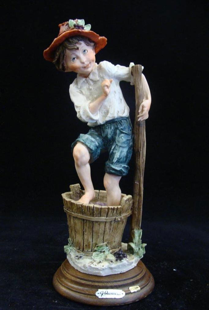 Giuseppe Armani Figurine: Autumn #3482C 1977 Edition. D: Giuseppe Armani Figurine: Autumn #3482C 1977 Edition. Depicts Young Lad Stomping Grapes in a Barrel. Auction Estimate: $100-200.