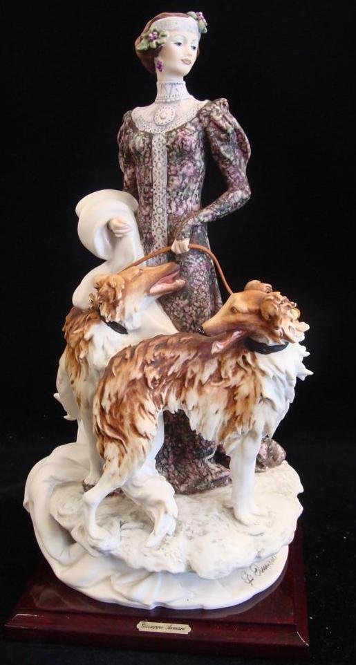 Giuseppe Armani Figurine: Lady with Borzoi #1122C. Depi: Giuseppe Armani Figurine: Lady with Borzoi #1122C. Depicts 1920's Style Woman With Two Borzois on Leather Leash. 15.5" Ht. Box (Armani but not Original) & COA. Auction Estimate: $400-600.