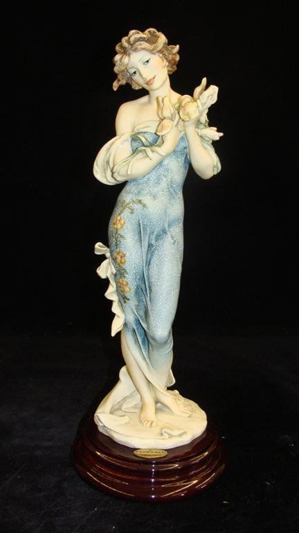 Giuseppe Armani Figurine: Iris #628E. 1995 Event Piece.: Giuseppe Armani Figurine: Iris #628E. 1995 Event Piece. Artist Signed Connie Ribaudo. Depicts Lady in Long Gown holding Bouquet of Iris'. 14" Ht. Box & COA. Auction Estimate: $300-500.