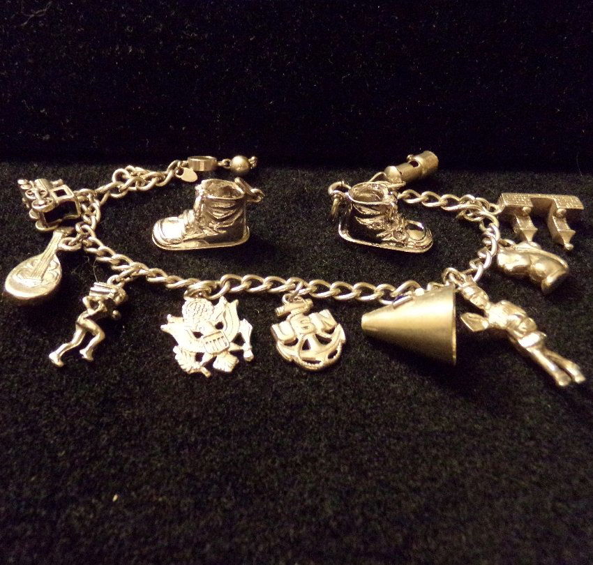 Sterling Silver Vintage Charm Bracelet & 12 Charms: Sterling Silver Charm Bracelet & Charms. 2 Wells 3D baby shoes (not attached to bracelet) and ten 3d charms on 7.5" bracelet. Charms include: US Navy, squirrel, train, mandolin,etc 39.4gr.