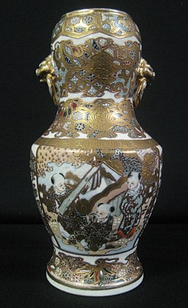 Japanese Satsuma Earthenware Vase: Japanese Satsuma earthenware vase decorated with figures and heavy gilding - measures 7 3/4" high x 4" diameter.