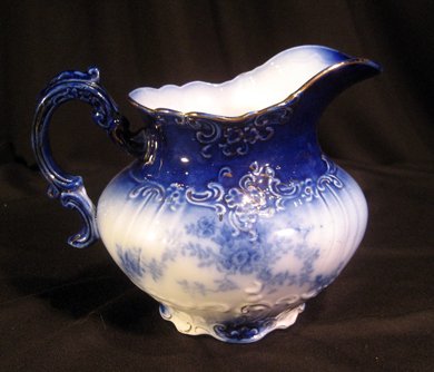 Century semi-porcelain flow blue pitcher.: Century semi-porcelain flow blue pitcher, 6-3/4" high.