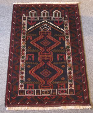 Persian Baluchi Prayer Rug: Baluchi Prayer Rug ORIGIN: Iran MATERIAL(S): Wool COLORS: deep navy, reds, greens, and others DETAILS: hand-knotted SIZE/DIMENSIONS: 2'10" x 4'6"