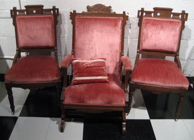 3pc Victorian Eastlake Walnut Parlor Set: Victorian Eastlake walnut parlor set: platform rocking armchair and two side chairs with demi arms - all with pink velvet upholstery.