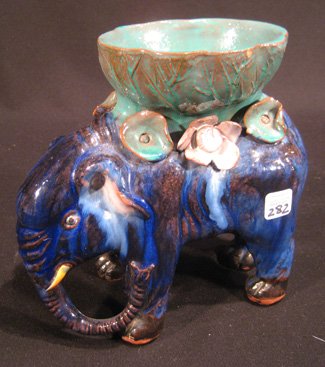 Blue glazed pottery elephant: Blue to green glazed pottery elephant vase, 7-1/2" high - some chips.